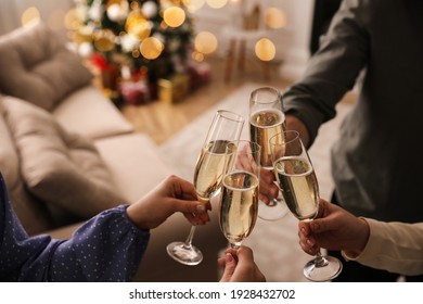 People clinking glasses with champagne at home, closeup