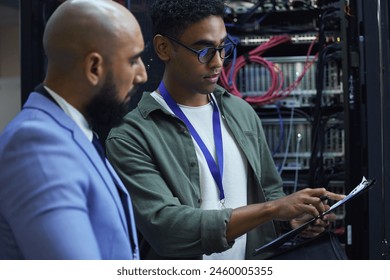 People, clipboard and technician engineer in server room, employees and programmers with paperwork. Men, colleagues and support for machine maintenance, processor hardware and teamwork for system