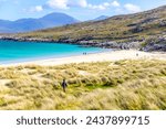 People at a colorful sunny beach at Lewis and Harris, Scotland