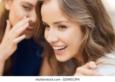 people, communication and friendship concept - smiling young women gossiping and whispering secrets