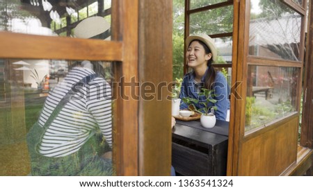 people communication and friendship concept. smiling young women drinking tea and gossiping at japanese local cafe in wooden historic house kyoto japan. girls laughing while doing tea ceremony.