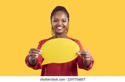 People And Communication. Paper Blank Mockup Of Speech Bubble In Hands Of Smiling African American Woman On Yellow Background. Close Up Of Young Woman Holding Speech Bubble With Empty Space For Text.