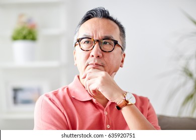 People Concept - Asian Man Thinking At Home