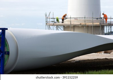 People constructing a wind-turbine