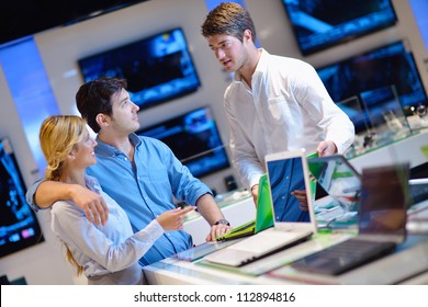 People In Consumer Electronics  Retail Store Looking At Latest Laptop, Television And Photo Camera To Buy