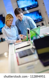 People In Consumer Electronics  Retail Store Looking At Latest Laptop, Television And Photo Camera To Buy