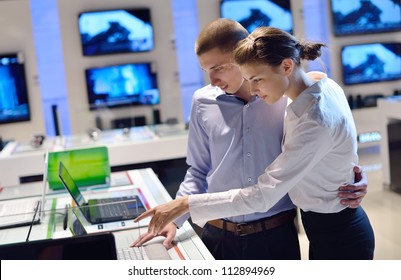 People In Consumer Electronics  Retail Store Looking At Latest Laptop, Television And Photo Camera To Buy