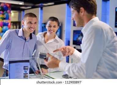 People In Consumer Electronics  Retail Store Looking At Latest Laptop, Television And Photo Camera To Buy