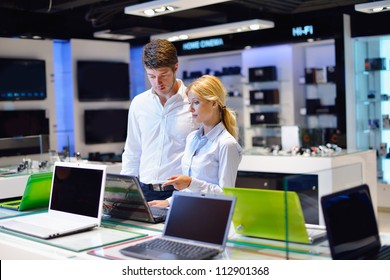 People In Consumer Electronics  Retail Store Looking At Latest Laptop, Television And Photo Camera To Buy