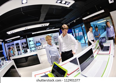 People In Consumer Electronics  Retail Store Looking At Latest Laptop, Television And Photo Camera To Buy