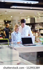 People In Consumer Electronics  Retail Store Looking At Latest Laptop, Television And Photo Camera To Buy