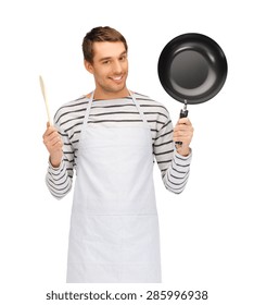 People, Cooking And Culinary Concept - Happy Man Or Cook In Apron With Frying Pan And Wooden Spoon