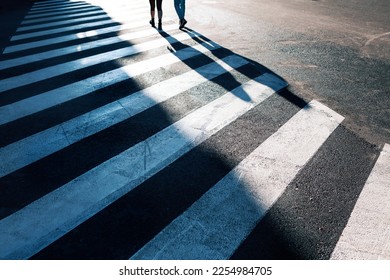 People Crossing City Street . Shadow on Urban Crosswalk