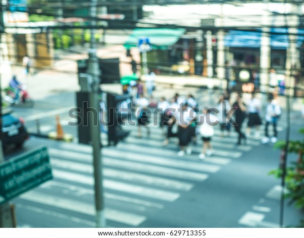People crossing the road on the\
crossing line in rush hour of Bangkok city. Blurry\
focus