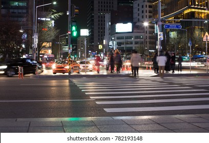 People Crossing The Street At Night In Seoul, Korea. Sejong. Gwanghwamun.