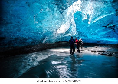 People Crossing Underground River Beneath The Glacier In Iceland