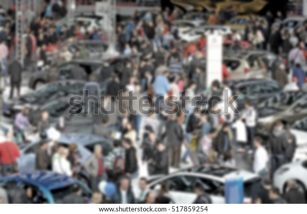 People crowd visit a trade show, humans\
unrecognizable. Background with an intentional\
blur