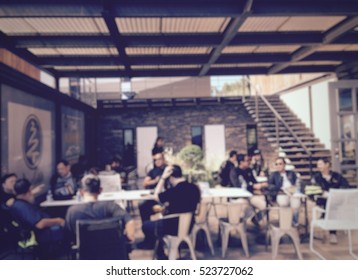 People Crowded Meeting In Terrace Of Coffee Shop. Blur Image Use For Background.
