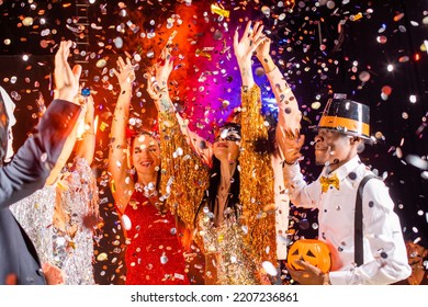 People Dance At Halloween Party With Champagne Glasses. Friends In The Costumes In Nightclub