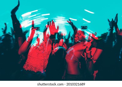 People dancing in a music festival in double color exposure effect