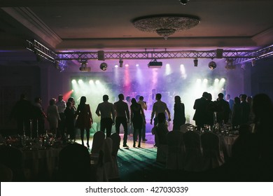 People dancing in the neon lights during the wedding party