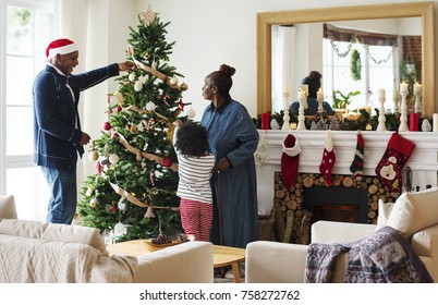 People decorating Christmas tree