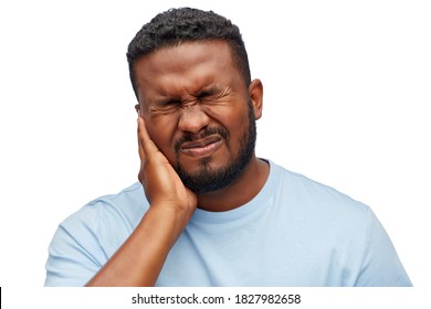 people, dentistry and health problem concept - african american man suffering from toothache over white background