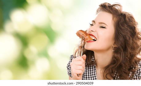 people, diet and food concept - hungry young woman eating meat on fork over green natural background