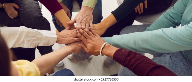 Mensen van verschillende leeftijden en nationaliteiten vouwen elkaar de handen op elkaar en symboliseren hun eenheid en steun. Team van mensen die zijn opgezet voor productief werk en een positief resultaat. Close up.