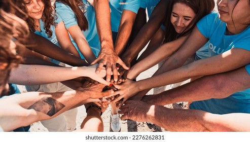 People of different ages and races are united to protect environment from pollution. Happy volunteers stacking hands together to cheer and boost team spirit. Friendship, teamwork, volunteering. - Powered by Shutterstock