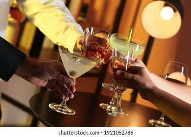 People With Different Alcohol Drinks Clinking Glasses Indoors, Closeup