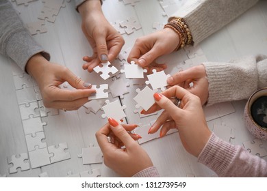 People Doing Puzzle At Table