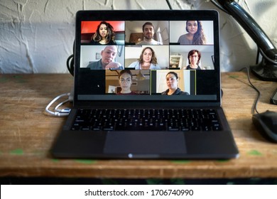 People doing a virtual meeting online.  Laptop on work from home desk.  Coworkers in a team meeting during COVID-19 coronavirus pandemic. - Shutterstock ID 1706740990