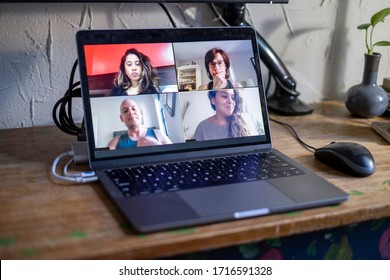 People doing a virtual meeting online.  Laptop on work from home desk.  Coworkers in a team meeting during COVID-19 coronavirus pandemic. - Powered by Shutterstock