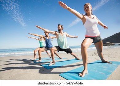 People Doing Yoga On The Beach On A Sunny Day