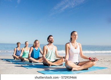 People Doing Yoga On The Beach On A Sunny Day