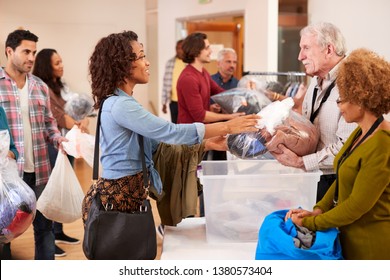 People Donating Clothing To Charity Collection In Community Center - Powered by Shutterstock