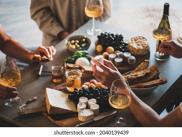 People drinking orange wine eating tasty snacks - Shutterstock ID 2040139439