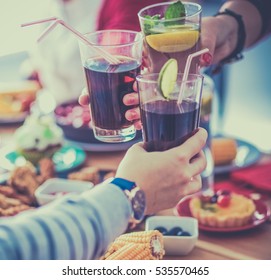 People with drinks while sitting at the dining table