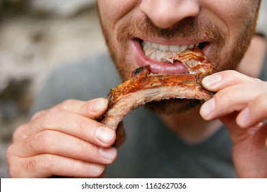 People Eat Food. Man Eating Barbecue Ribs In Grill Bar Closeup. Male Eating Spareribs In Steak House. High Resolution 