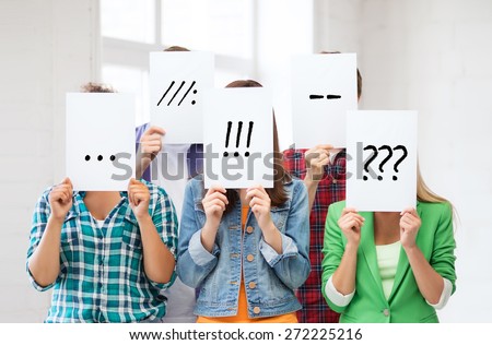 people, emotions and communication concept - group of friends or students covering faces with paper sheets