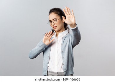 People, Emotions And Lifestyle Concept. Portrait Of Displeased And Disgusted Asian Woman Defending Herself From Someone Coughing Close To Her, Turn Away And Raise Hands From Glimmering Light