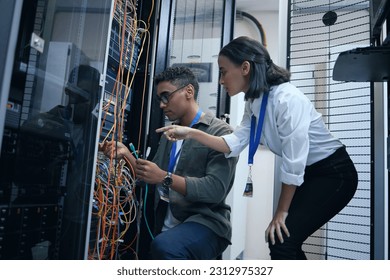 IT people, engineer or server room cable for programming or connection maintenance. Man and woman technician in datacenter for network, cybersecurity software or data center problem or system upgrade - Powered by Shutterstock