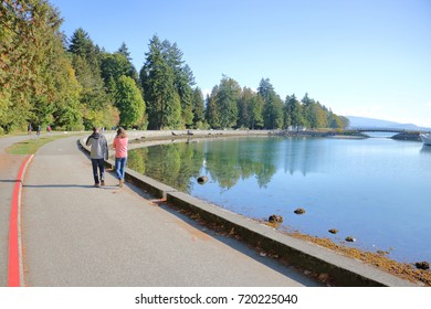 People enjoy a five kilometer seawall that surrounds Vancouver, Canada's world famous Stanley Park.  - Powered by Shutterstock