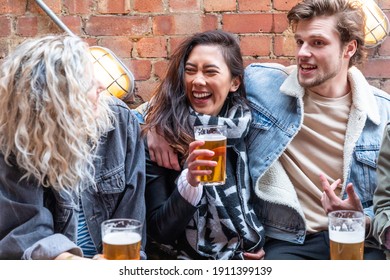 Menschen, die gemeinsam ein Bier in der Bierbrauerei genießen - Fröhlich lachende Männer und Frauen, die Pint-Glas sprechen und heben - Lifestyle- und Drink-Konzepte in London