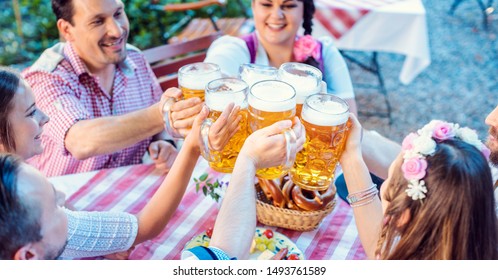 People enjoying food and drink in Bavarian beer garden on a sunny day