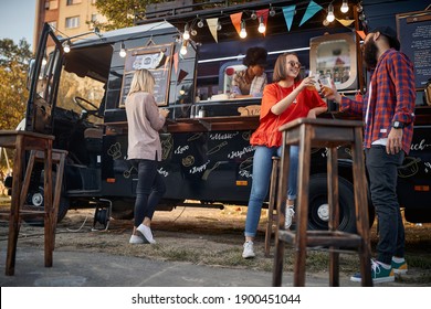 people enjoying in front of modified truck for mobile fast food service
