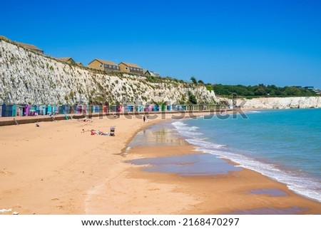 People enjoying sunshine on the sandy beach at Stone Bay in the seaside town of Broadstairs, east Kent, England