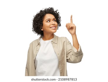 People, Ethnicity And Portrait Concept - Happy Smiling Woman In Shirt Pointing Finger Up Over White Background