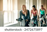 People, exercise bike and gym for cardio, training and cycling for fitness or spin class. Women, riding and stationary machine for workout challenge, aerobic instructor and equipment for practice